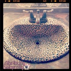 a leopard print sink with two faucets on the top and one faucet below it