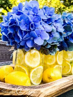 some lemons and blue flowers are in mason jars