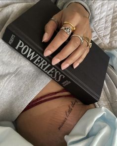 a woman laying on top of a bed next to a book with the word powerless written on it