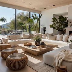 a living room filled with lots of furniture and large windows overlooking the mountains in the distance