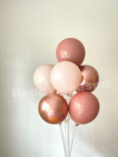 a bunch of pink and gold balloons in a vase