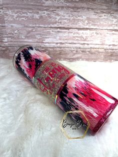 a pink and black tube with glitter on it sitting on top of a white rug