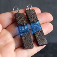 Stylish earrings made of wood and resin on silver clasp 925. This pair measures about 54 mm long and 13 mm wide. ► Your order will be packaged in a beautiful box, ideal for gifts, which is carefully packed in extra boxes for delivery. approximate delivery time takes 10-20 business days. ► Also look at all our wood resin jewelry - https://www.etsy.com/shop/SOGDbrand ► We also can produce our products under individual size and take into account all the wishes of the client. If you have any questio Wood Jewelry, Resin And Wood Earrings, Handmade Nature-inspired Resin Earrings, Handmade Blue Resin Earrings, Elegant Blue Resin Earrings, Blue Hypoallergenic Resin Earrings, Wooden Anniversary Gift, Wood Resin Jewelry, Casual Earrings