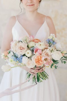 a woman holding a bouquet of flowers in her hands