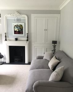 a living room filled with furniture and a fire place under a mirror on the wall