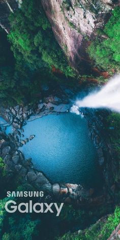 an aerial view of a blue lake surrounded by trees and rocks with the words samsung galaxy above it