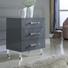 a grey cabinet with three drawers and two vases on top