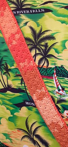 a close up of a tie with palm trees and boats on the water in front of it