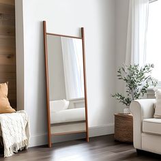 a living room with a white couch and large mirror