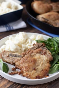 a white plate topped with meat and mashed potatoes