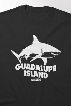 a black t - shirt that says guadalajara island mexico with a white shark on it