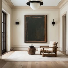 an empty living room with a painting hanging on the wall and two chairs in front of it