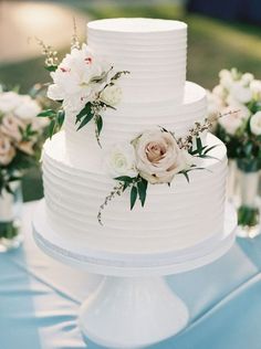 a white wedding cake with flowers on top