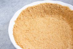 a white bowl filled with brown sugar on top of a gray countertop next to a knife