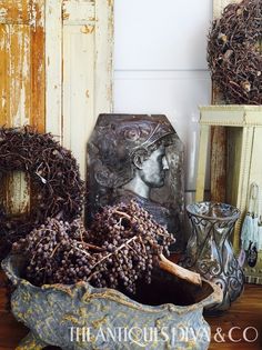 an antique bowl filled with grapes next to other items