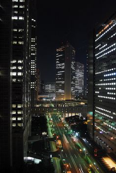 cityscape at night with traffic and skyscrapers in the background