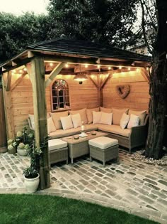 an outdoor living area with couches and lights on the roof, surrounded by brick pavers