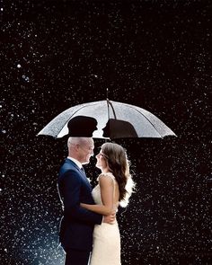 a bride and groom standing under an umbrella in the rain