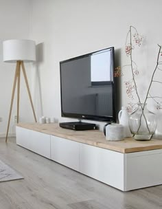 a flat screen tv sitting on top of a white entertainment center in a living room