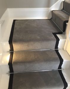 a carpeted staircase with black and white trim on the treads is seen in this image