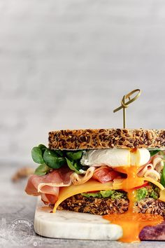 a sandwich with ham, lettuce, cheese and other toppings on it