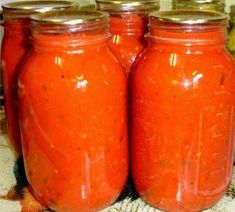 three jars filled with red liquid sitting on top of a table