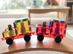 two toy train cars sitting on top of a wooden table