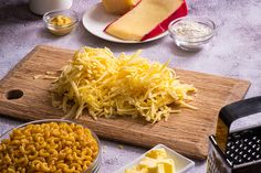 cheese is cut up on a cutting board with other ingredients to make macaroni and cheese