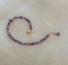 Amethyst Bracelet Natural Stone Bracelet Purple Bracelet This beautiful bracelet is made of natural amethyst crystal beads. The beads are 4 mm in diameter and one bead is 6 mm in diameter and is located on one side of the bracelet along with the brass gold beads. At the end of the bracelet is a gold brass clasp and a small extension of 2 cm to adjust the length. At the end of the extension is a pendant amethyst pearl. The bracelet is elegant and can be a wonderful gift for your love, for your mo Purple Beaded Birthstone Bracelets As Gift, Purple Beaded Birthstone Bracelets For Gift, Purple Birthstone Beaded Bracelets As Gift, Purple Birthstone Beaded Bracelets For Gift, Amethyst Gemstone Beads Bracelets As Gift, Lavender Amethyst Crystal Bracelet As Gift, Spiritual Amethyst Beaded Birthstone Bracelet, Adjustable Amethyst Beaded Bracelets With Birthstone, Amethyst Beaded Bracelet With Birthstone As Gift