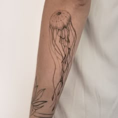 a man with a tattoo on his arm has a jellyfish in it's mouth