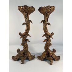 a pair of ornately carved wooden candlesticks