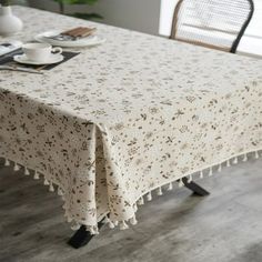 the table is covered with a white and black floral print, which has tasseled edges