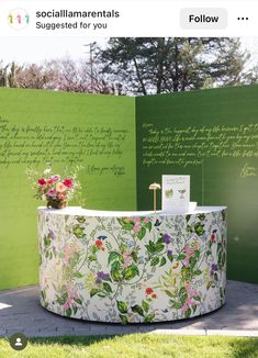 a green wall with flowers and writing on it