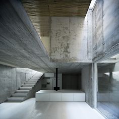 an empty room with concrete walls and stairs