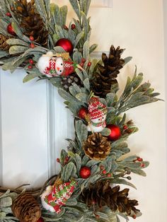 a christmas wreath with pine cones and ornaments