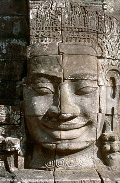 the face of an ancient statue is shown in this photo, it looks like he's smiling