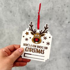 a hand holding a christmas ornament with reindeer's head and stars on it