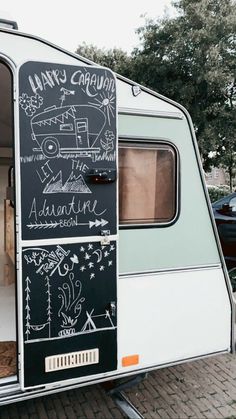 an old camper with chalk writing on the door