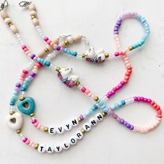 several bracelets with name charms on them sitting on a white counter top next to each other