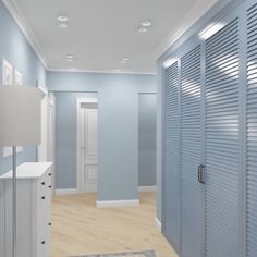 an empty hallway with blue walls and white shutters on the doors is seen in this image