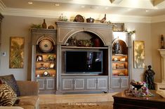 a living room filled with furniture and a flat screen tv mounted on a wall above a fireplace