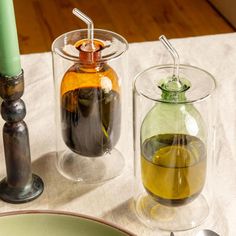 there are two glass containers on the table next to each other with drinks in them