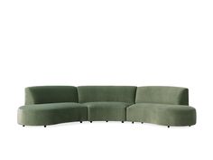 a green sectional couch sitting on top of a white floor