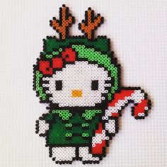 a cross stitch christmas ornament with a hello kitty on it's head