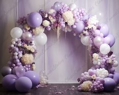 a purple and white balloon arch with flowers, balloons and streamers on the floor