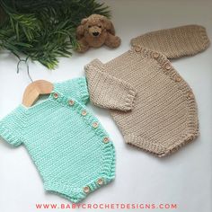 two knitted onesuits and a teddy bear on a white table with greenery