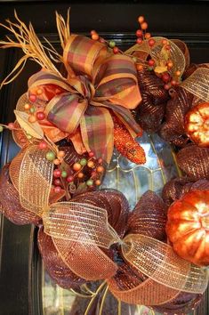 a wreath with pumpkins and leaves on it