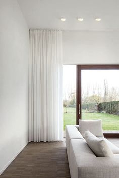 a white couch sitting in front of a window