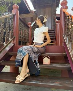 a woman sitting on the steps in front of a building with stairs and railings