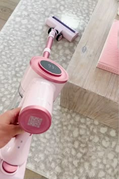 a pink hair dryer sitting on top of a table